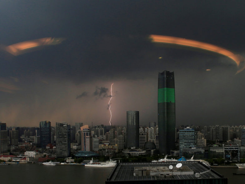 FILE PHOTO - A streak of lightning is seen above the skyline of Shanghai, China, August 19, 2016. Picture taken through a glass window.